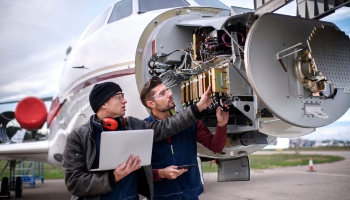 An aircraft mechanic in training, looking at an engine.