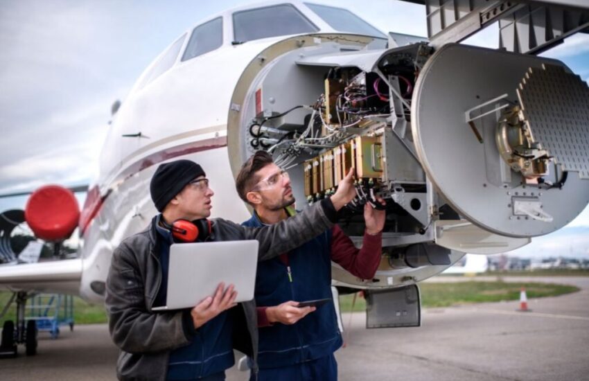 An aircraft mechanic in training, looking at an engine.