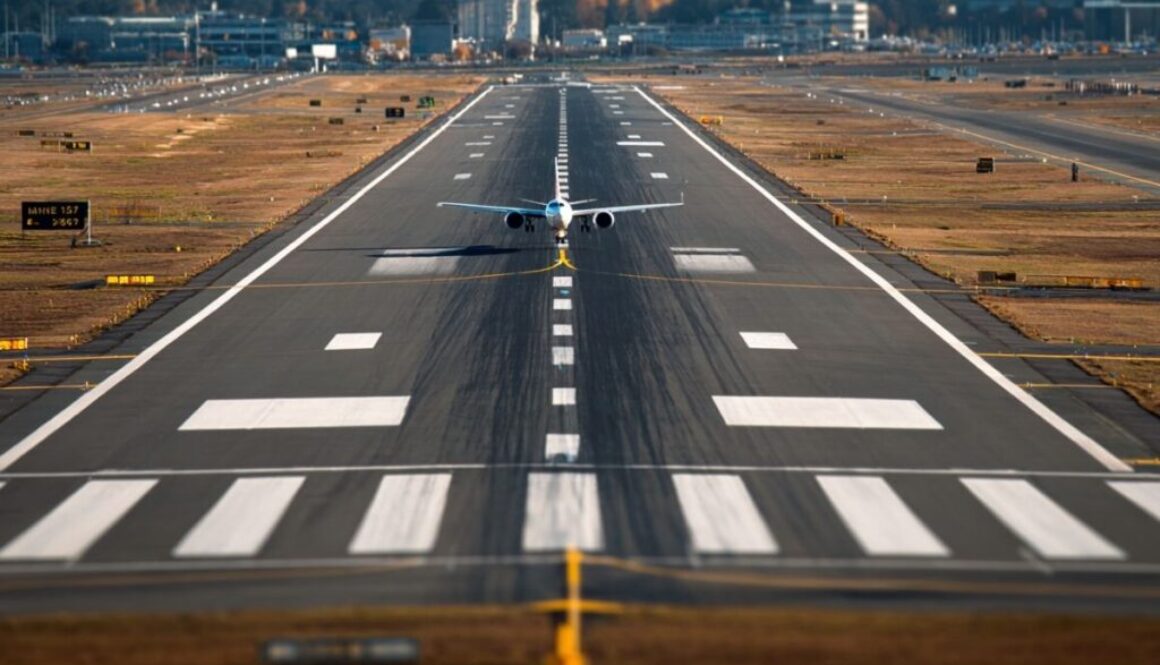 Airplane aligned on a runway with clear runway markings including centerline, threshold bars, and touchdown zone markings.