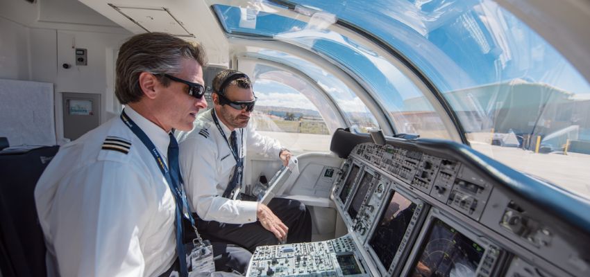 Two pilots in the cockpit actively monitoring controls while taxiing the aircraft on the ground at an airport